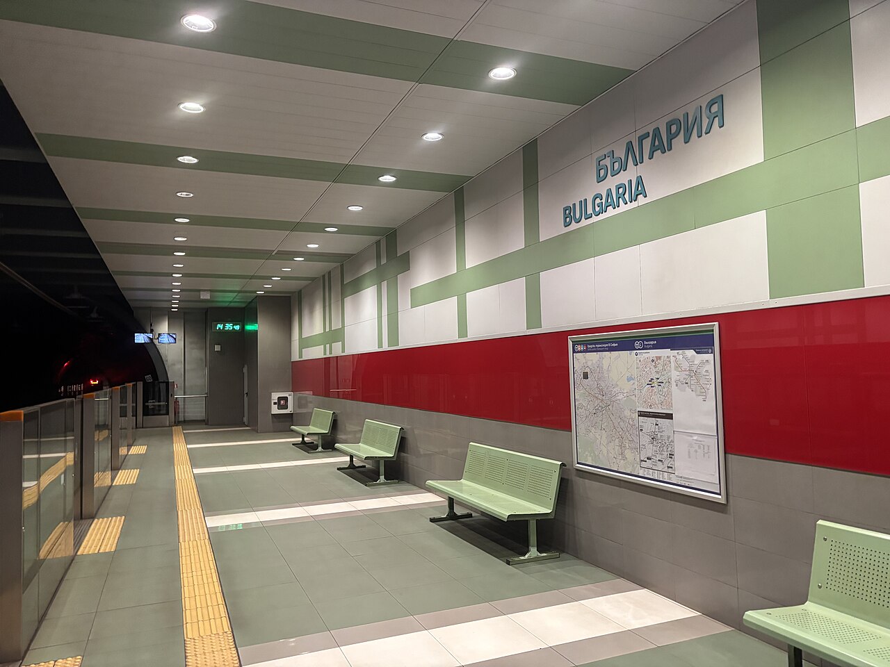 Nástupište stanice metra so zelenými lavicami, mapou siete na stene a nápisom Bulgaria